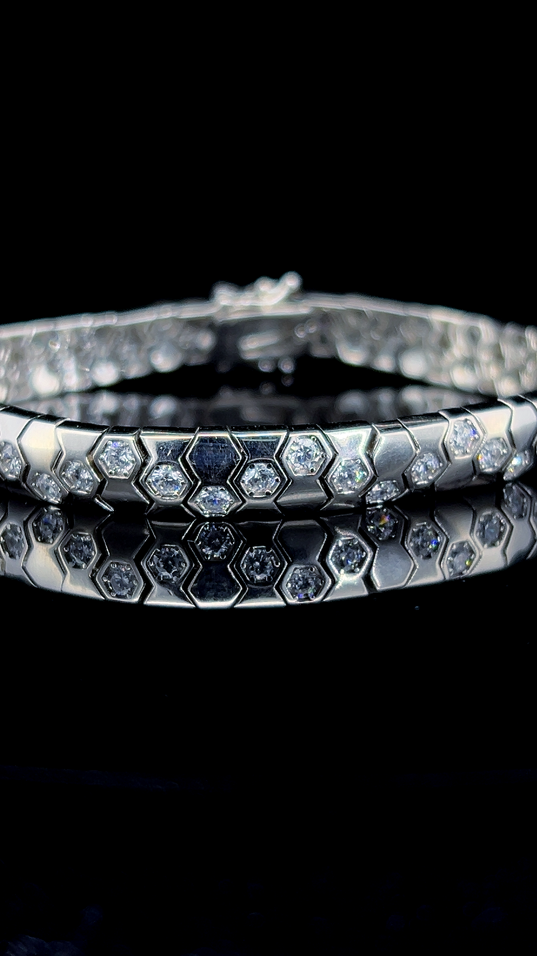 925 sterling silver geometric link bracelet featuring clear cubic zirconia stones on a dark reflective surface.