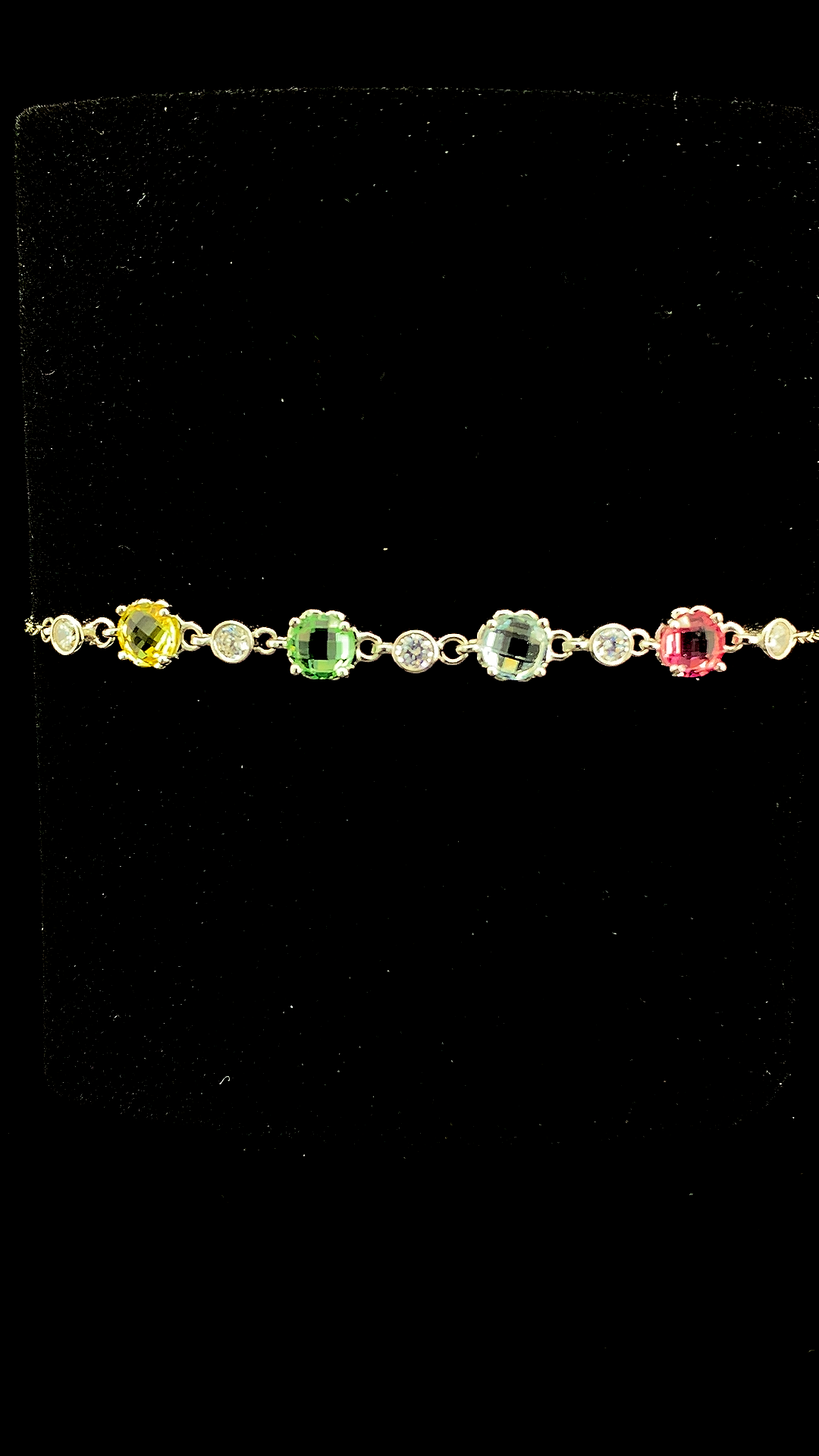 Delicate 925 sterling silver chain bracelet featuring multi-colored and clear cubic zirconia stones against a dark background.